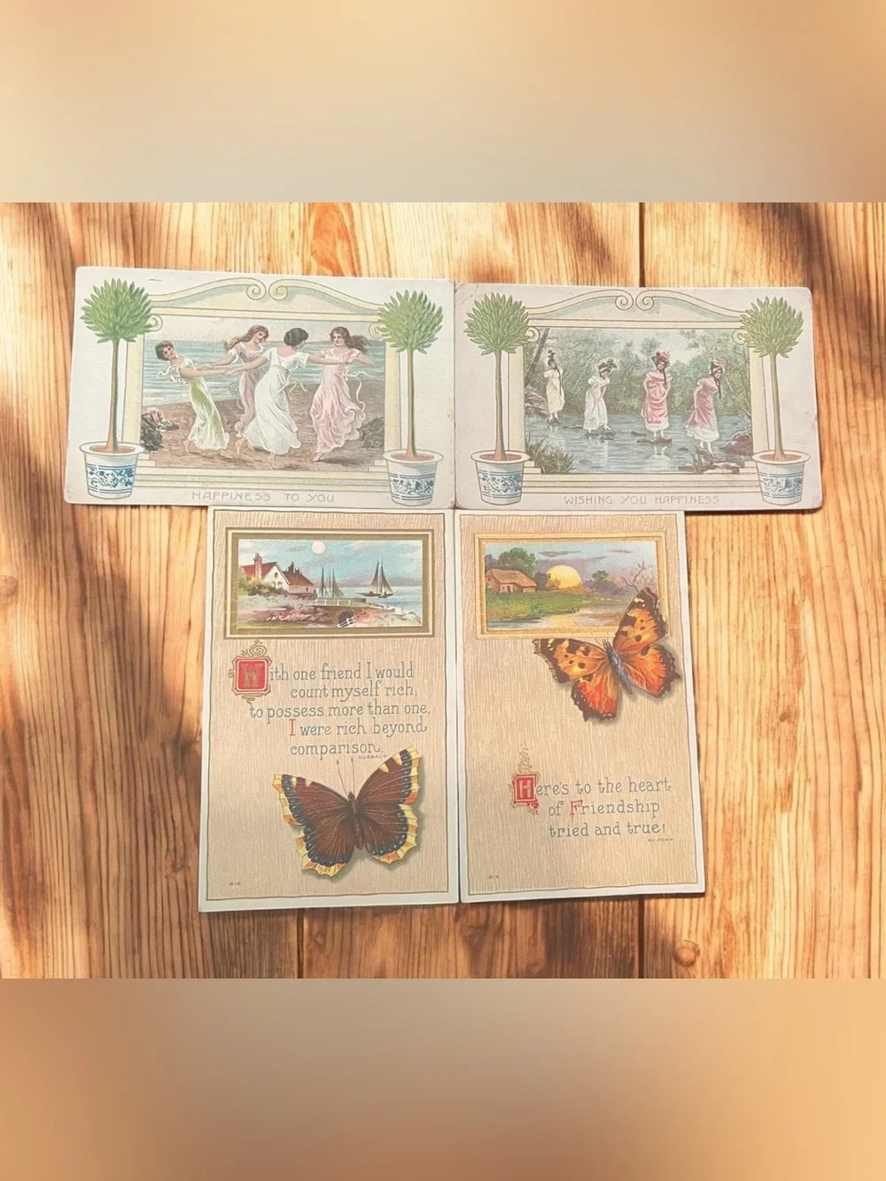A set of four antique postcards with friendship and happiness sentiments.